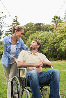Happy man in wheelchair talking with partner