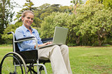 Smiling woman in a wheelchair with a laptop