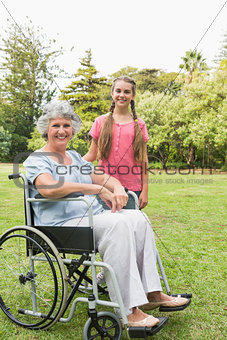 Smiling granddaughter with grandmother in her wheelchair