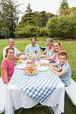 Happy extended family having dinner outdoors at picnic table
