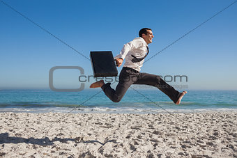 Cheerful businessman jumping on the beach