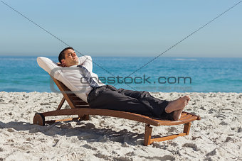 Young businessman relaxing on a deck chair
