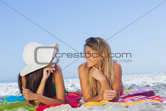 Two pretty women lying on the sand