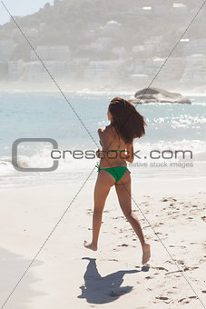 Gorgeous brunette running to the sea