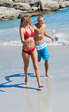 Cheerful couple in swimsuit walking together