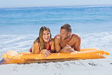 Cheerful cute couple in swimsuit taking sun
