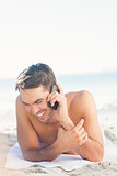 Smiling handsome man on the beach on the phone