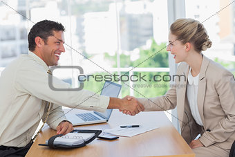 Blonde woman shaking hands while having an interview