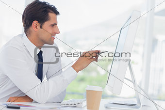 Concentrated businessman analyzing documents on his computer screen