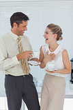 Stylish workmates laughing while having coffee together