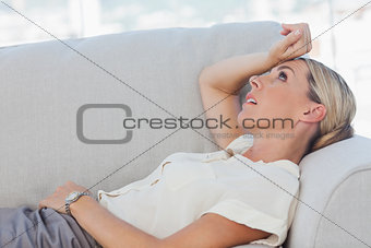 Exhausted businesswoman lying on sofa