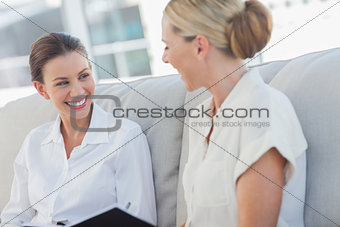 Cheerful businesswomen talking and working together