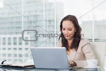 Concentrated businesswoman working on her laptop