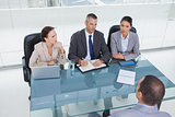 Concentrated business team interviewing experienced man
