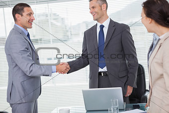 Smiling businessmen standing and shaking hands