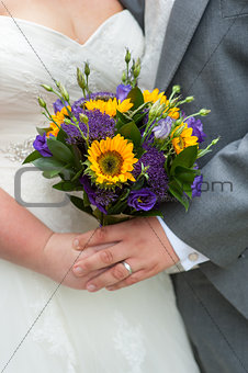 bride and groom holding a wedding bouquet