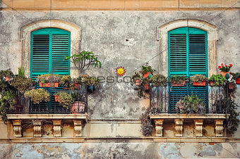 Beautiful vintage balcony with colorful flowers and doors
