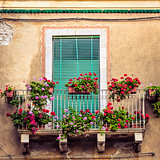 Beautiful vintage balcony with colorful flowers and door
