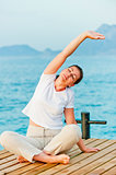 young woman engaged in Pilates by the Sea