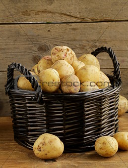 fresh organic potatoes on a wooden background, rustic style
