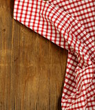 Wooden background with red checkered kitchen towel