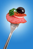 Salami and sausage slice on fork