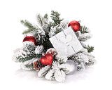 Gift box and christmas decor on snowy fir tree