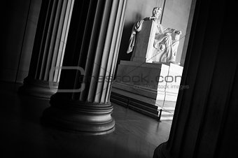 Statue of Abraham Lincoln seated behind columns at the Lincoln Memorial, Washington DC black and white