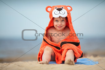 Cute little boy wearing tiger towel outdoors