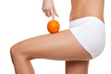 Woman with an orange showing a perfect skin