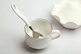 White cup, spoon and milk powder