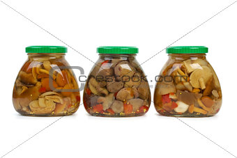Three glass jars with marinated mushrooms