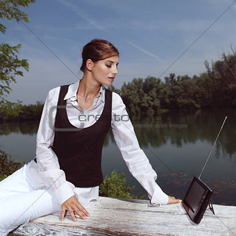 a woman with laptop in park
