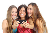 Group of three teenager girls laughing looking the smart phone
