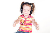 Beautiful little girl with headphones showing thumbs up
