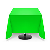 Square table with green tablecloth.