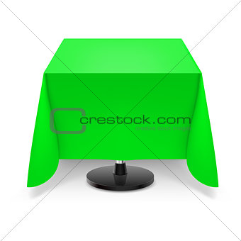 Square table with green tablecloth.