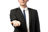 Businessman in dark suit holds out his hand flat