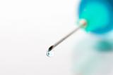 Drop of blue liquid on an injection needle