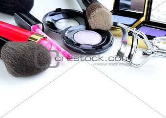 makeup set (shadows, lipstick, brush) on a white background