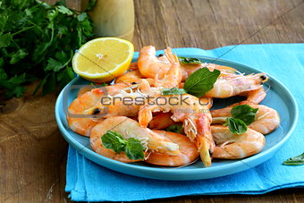 shrimp cooked with lemon and basil on a wooden table