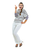 Full length portrait of happy young woman in sweater pointing on