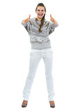 Full length portrait of happy young woman in sweater showing thu