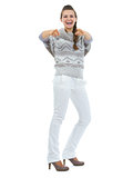 Full length portrait of smiling young woman in sweater pointing 