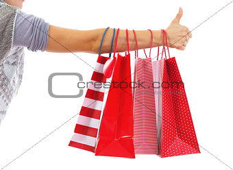 Closeup on young woman hand with christmas shopping bags showing