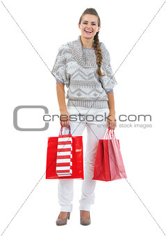 Full length portrait of happy young woman in sweater holding chr
