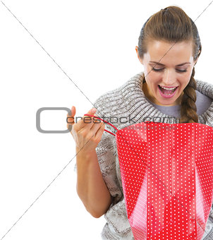 Closeup on happy young woman in sweater looking in christmas sho