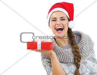 Happy young woman in sweater and christmas hat showing christmas