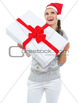 Happy young woman in sweater and christmas hat with big christma