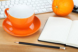 Coffee cup, orange fruit and office supplies